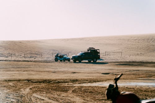 People Riding on Off Road Vehicles on a Desert Field