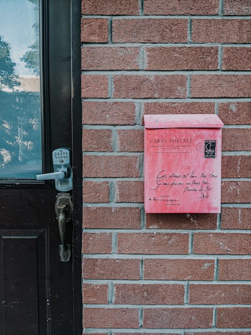 Washed Out Old Red Mailbox on Brick Wall