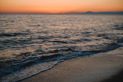 Sea Waves Kissing the Beach Shore During Sunset