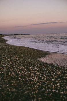 A tranquil seashore scene at sunset with gently lapping waves, offering a moment of natural peace and beauty.