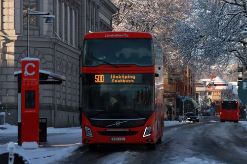Free Red double decker bus on snowy city street in Sweden during winter, showcasing urban transportation. Stock Photo