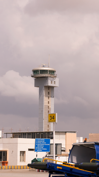 View of the air traffic control tower at Kempegowda Airport in Bangalore, India on a cloudy day.