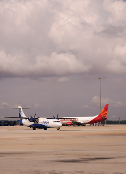 Commercial airplanes parked on a runway under a cloudy sky, capturing the essence of air travel.