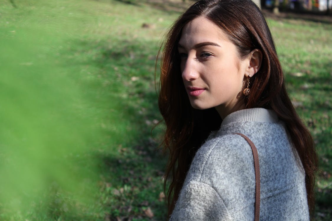 Free Woman in Gray Sweater Beside Grass Field Stock Photo