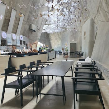 A stylish restaurant interior featuring origami ceiling decorations and contemporary furniture.