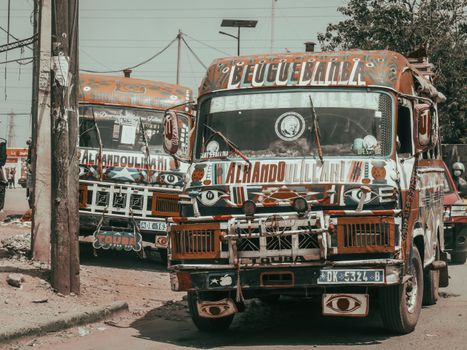 Vibrant buses showcasing African art and street life in an urban setting.