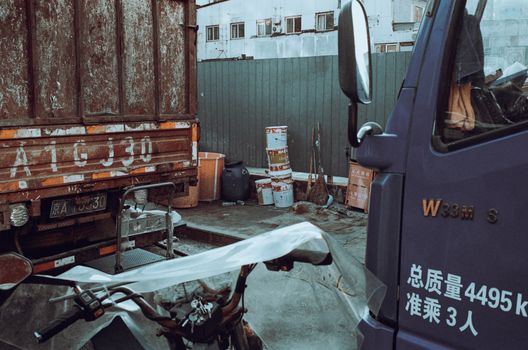 An industrial yard with parked trucks, showing urban equipment and storage containers.