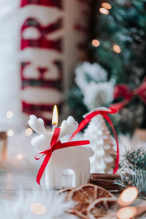 Free A close-up of a decorative candle with holiday ornaments creates a warm, festive atmosphere. Stock Photo