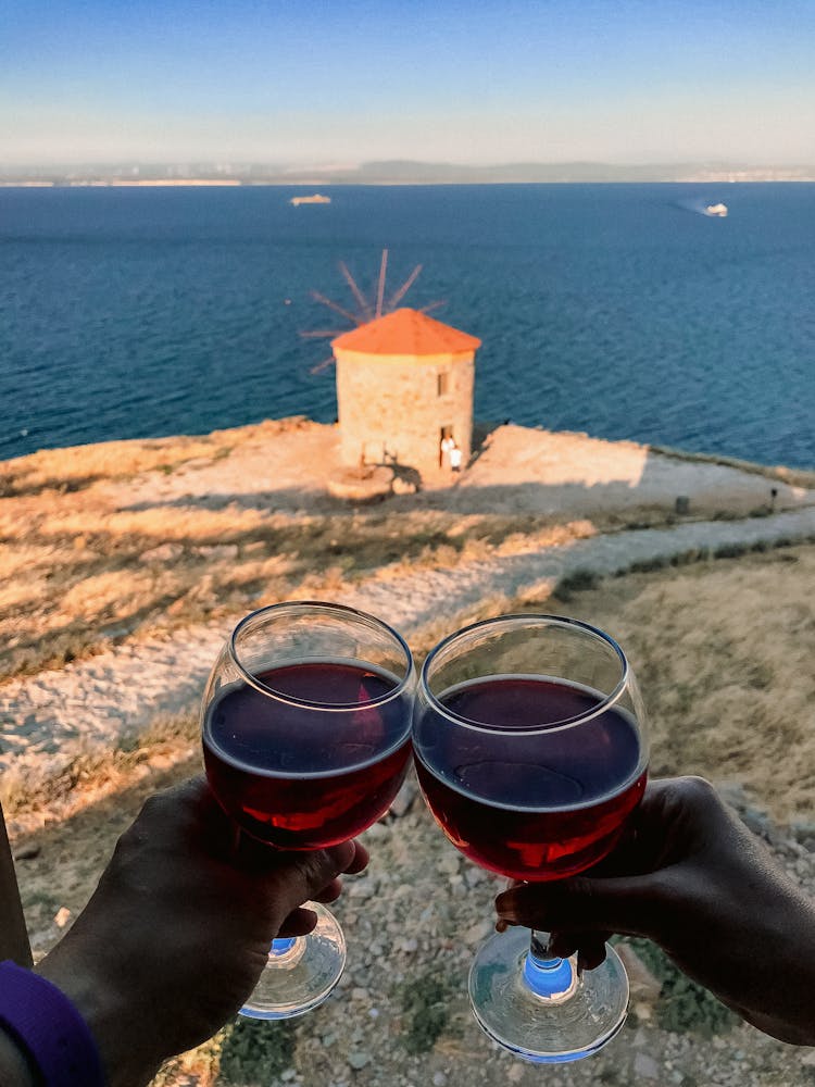 Tossing Wine Glasses Near Body Of Water 