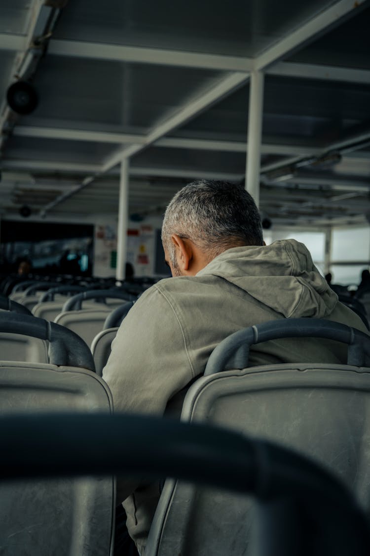 Person In Gray Hoodie Shirt Sitting Inside A Ferry Boat