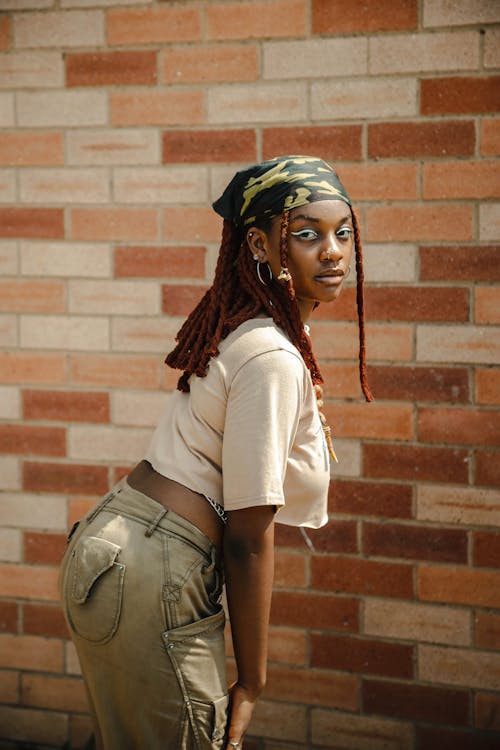 Základová fotografie zdarma na téma afroameričanka, černoška, cihlová zeď