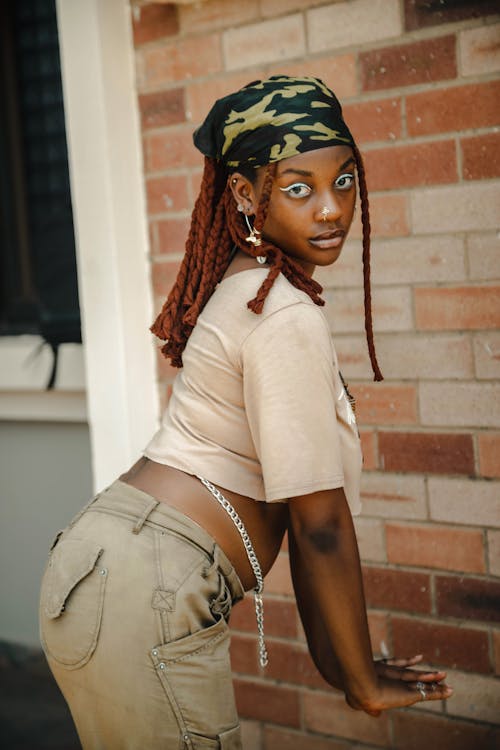 A Woman Posing in Front of Brick Wall