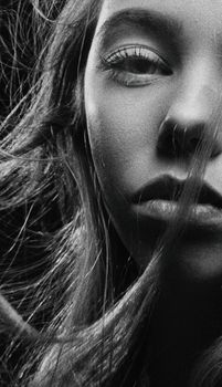 Stunning grayscale close-up portrait capturing the intricate details of a woman's face in monochrome tones.