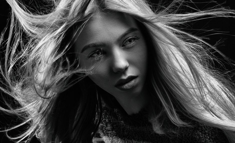 Artistic black and white portrait capturing an expressive woman's face with flowing hair.