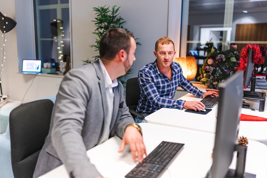 Two engineers sharing a monitor setup, photo by Utopix Pictures on Pexels