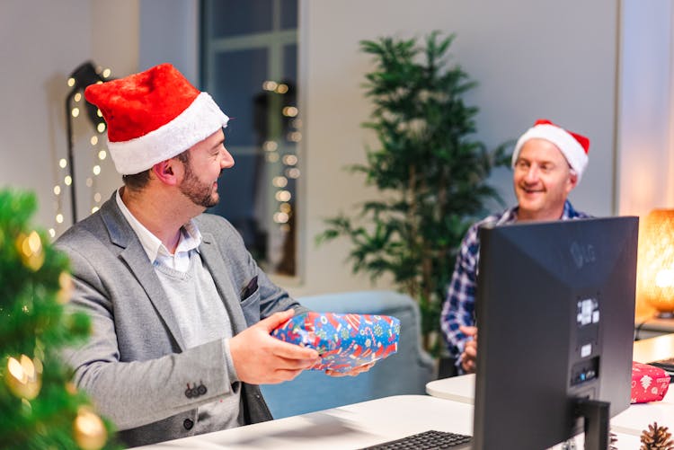 A Man Holding A Gift In An Office