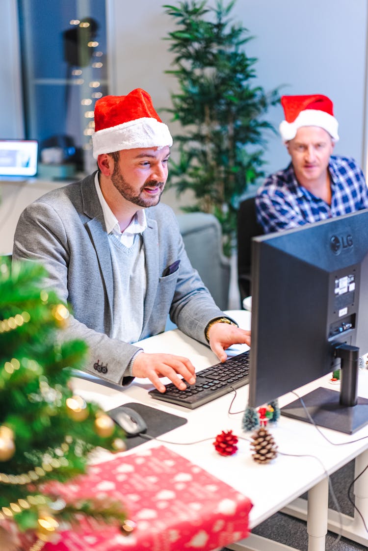 Men Working In The Office Wearing Santa Hat