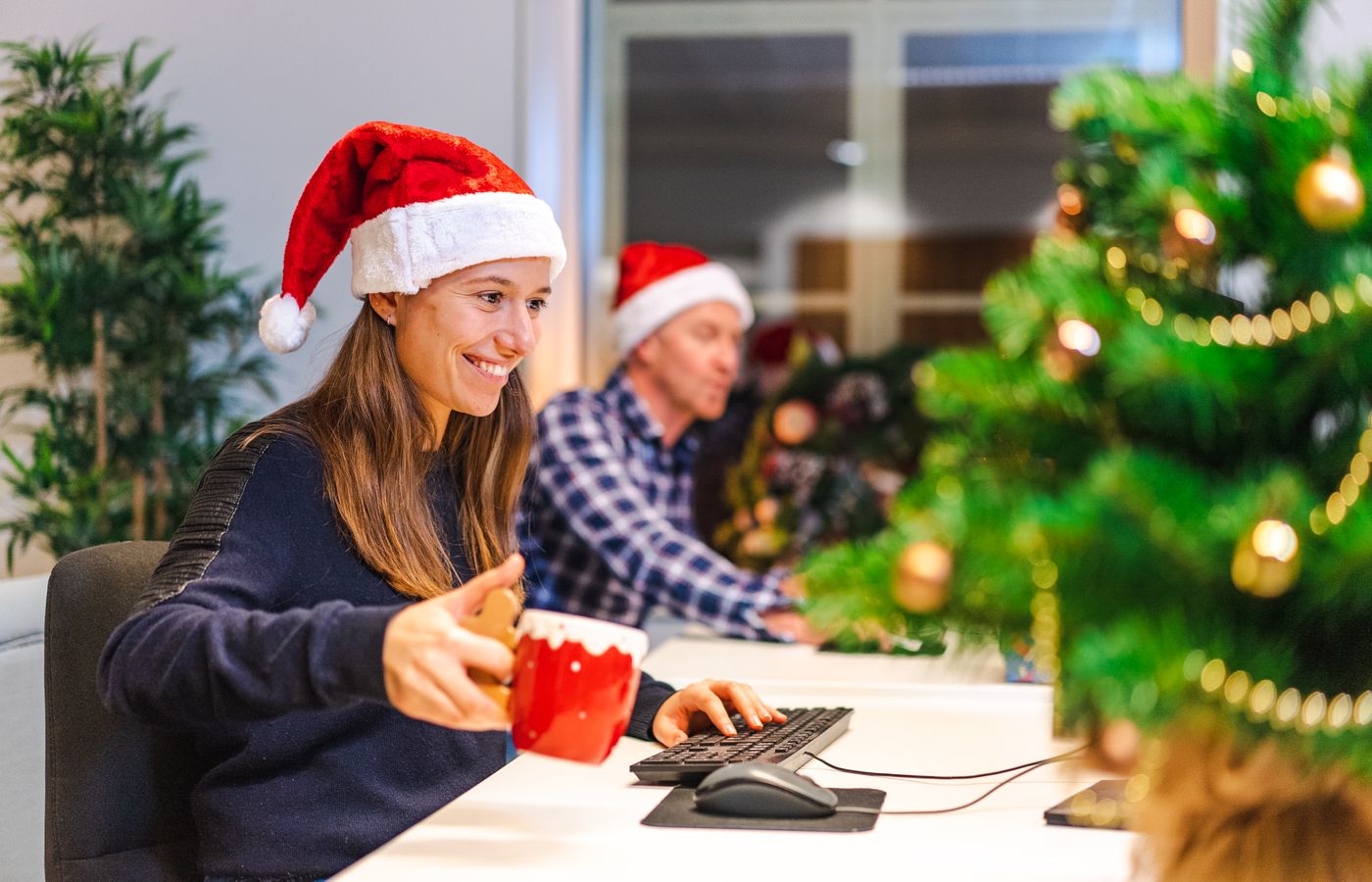 Office workers enjoying a festive atmosphere with Santa hats during work.