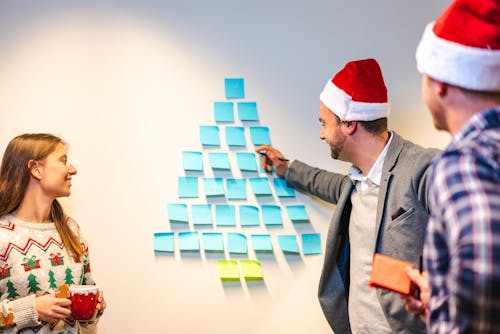 People Standing Beside the White Wall with Sticky Notes