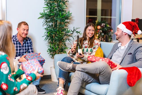 Smiling Family Sitting with Christmas Gifts and Wine