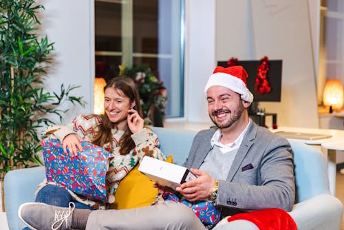 Smiling Couple Sitting with Christmas Gifts