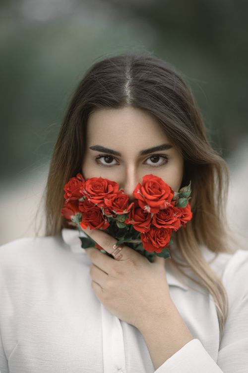 Free Young woman holding red roses, creating a stunning outdoor portrait in Urmia, Iran. Stock Photo