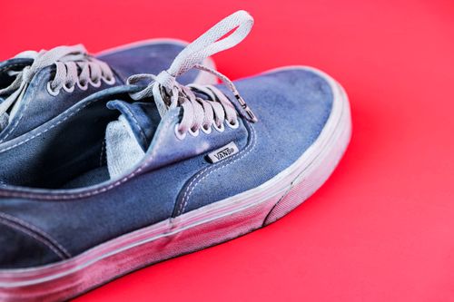 Free Stylish blue Vans sneakers on a bold pink background, showcasing modern casual footwear. Stock Photo