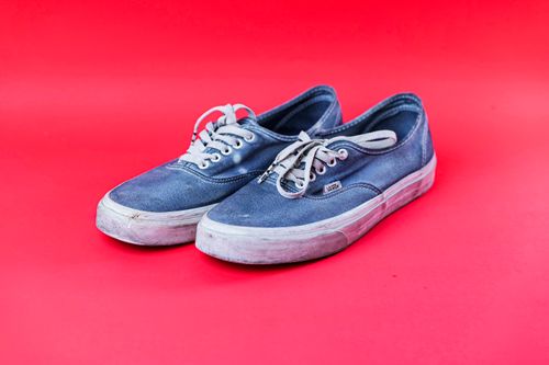 Free Stylish blue sneakers placed on a bold red backdrop, showcasing fashion footwear. Stock Photo
