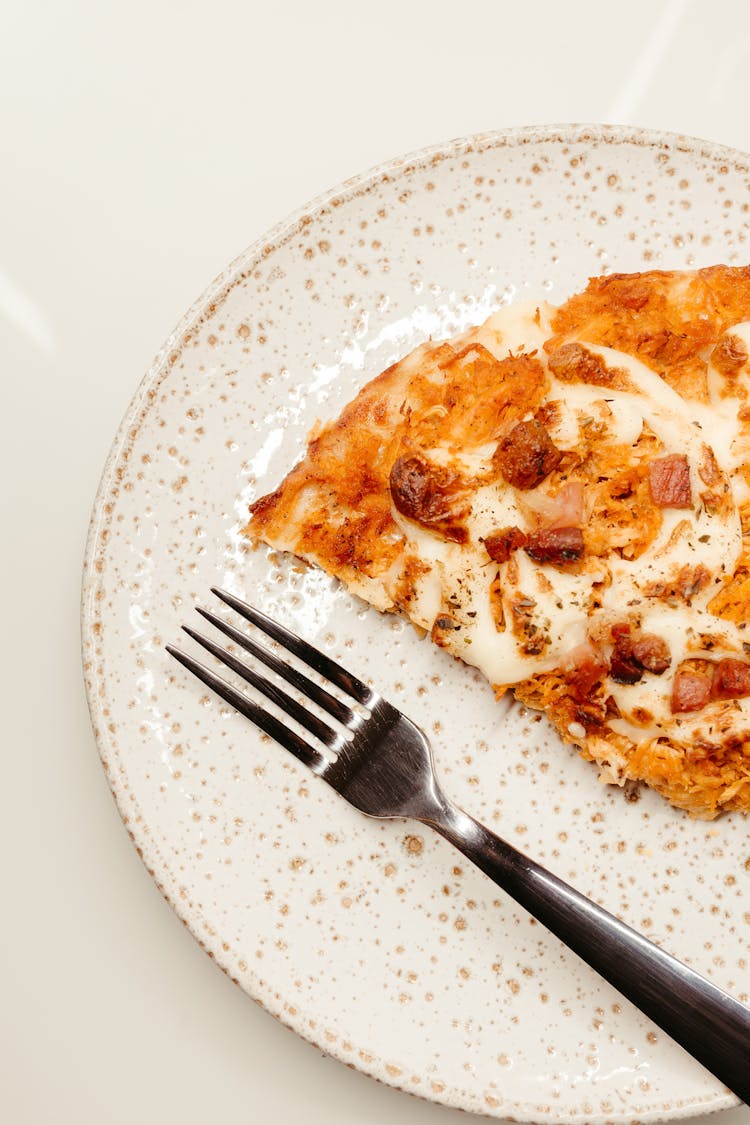 Slice Of Pizza And Fork On Ceramic Plate