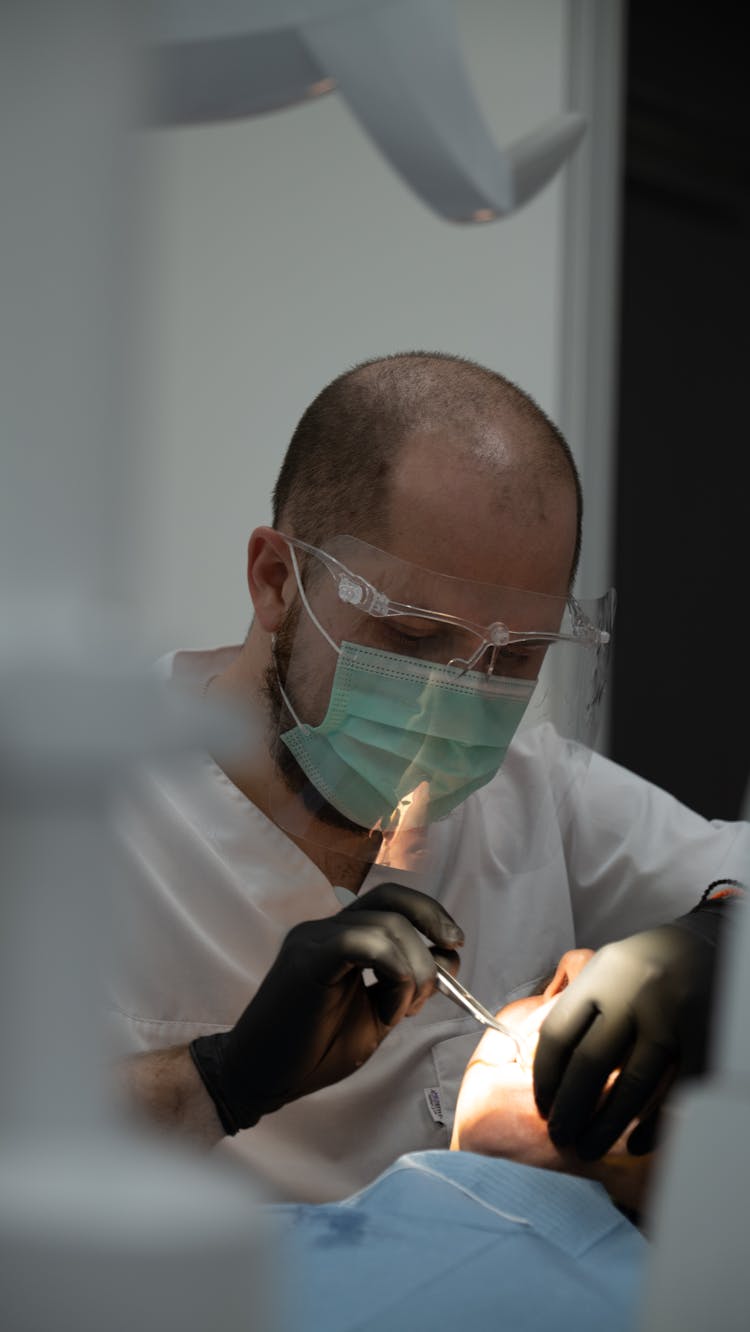 A Dentist Tending A Patient