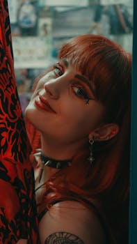 Portrait of a smiling redhead woman with edgy makeup and choker indoors. Vibrant and expressive style.