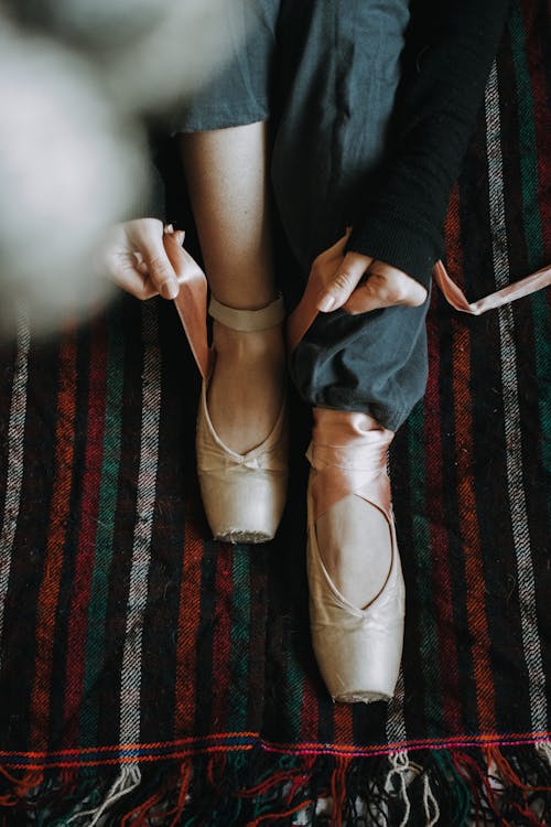 A Close-Up Shot of a Person Tying a Ballet Shoe