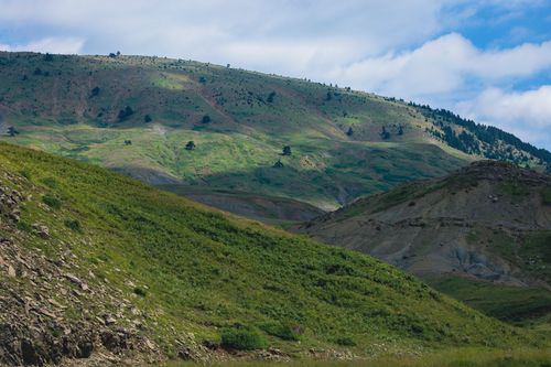 Free Breathtaking green mountain landscape under a vibrant blue sky, depicting nature's beauty. Stock Photo