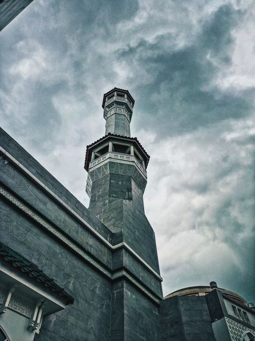 Free Low angle view of a mosque tower in Gua Musang, Malaysia, with a dramatic cloudy sky backdrop. Stock Photo