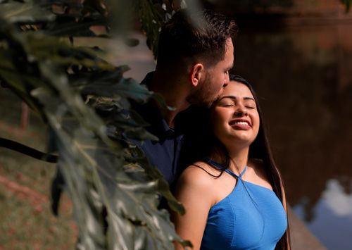 Free A couple sharing an intimate moment outdoors, surrounded by greenery. Stock Photo