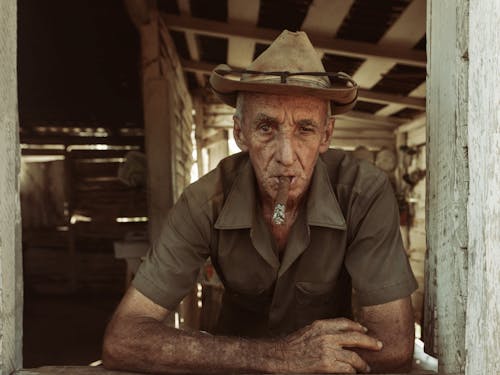 Elderly Man in Hat Smoking Cigar