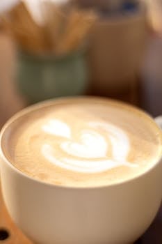 A creamy cappuccino in a white cup with heart-shaped latte art. Perfect for coffee lovers.