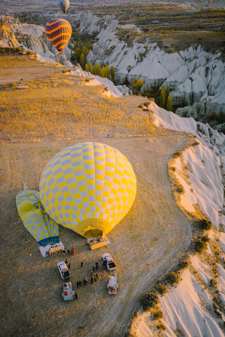 Hot Air Balloons On The Ground By A Cliff