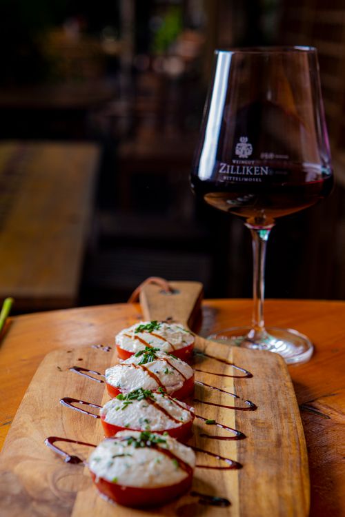Free Delightful finger food paired with red wine served elegantly on a wooden tray. Stock Photo