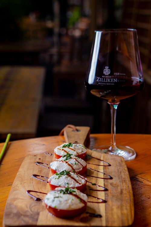 Free Close-up of Italian bruschetta with balsamic drizzle and wine glass, perfect for elegant dining. Stock Photo