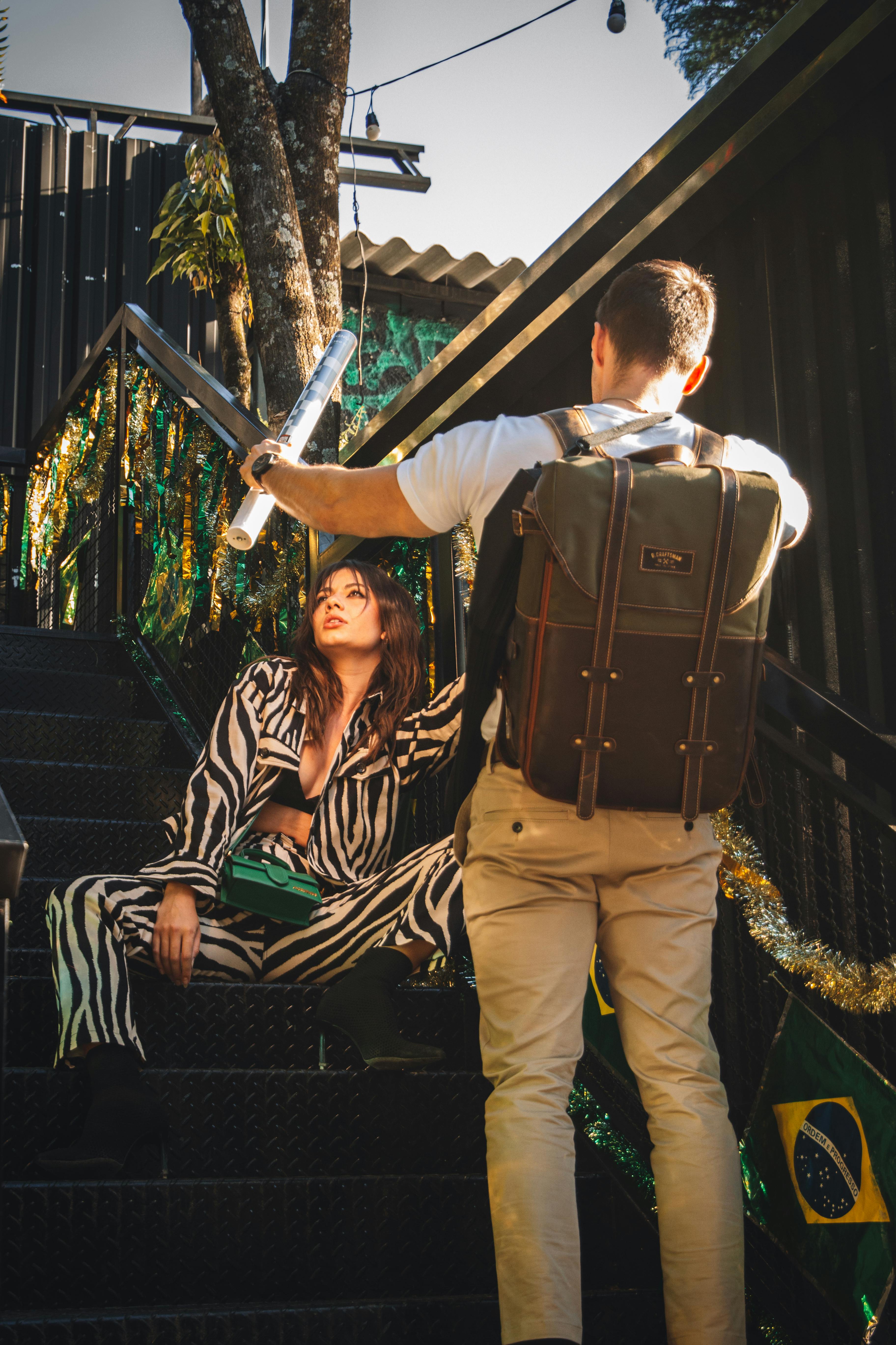 Free Photographer capturing a model in a stylish zebra print outfit on decorated stairs. Stock Photo