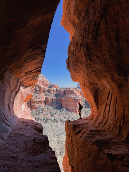 Free A Man Standing on a Rock Formation Stock Photo