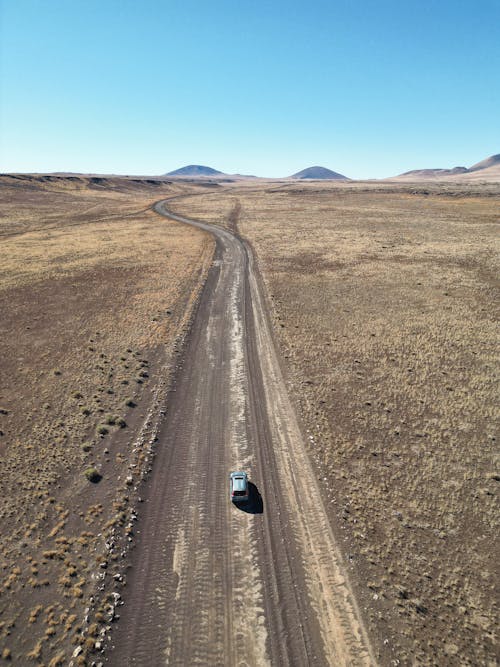 High Angle Shot of Car on Dirt Road 