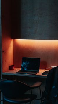 A cozy workspace in Istanbul features a laptop, chair, and warm lighting.
