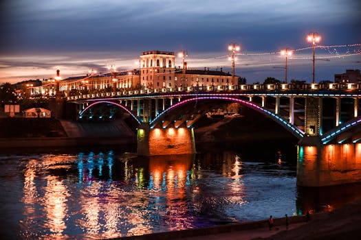 Vibrant cityscape of an illuminated bridge over a river in Vitebsk, Belarus at dusk.