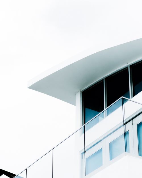 Free Low angle view of sleek modern building facade with glass balustrade and large windows. Stock Photo