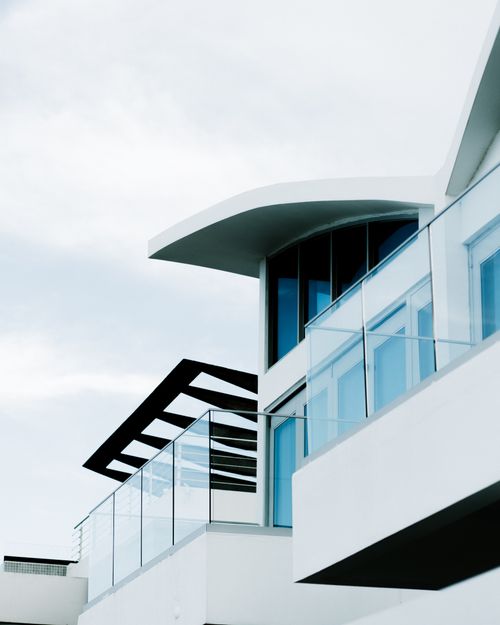 Free Low angle view of a modern building featuring glass balconies against a cloudy sky. Stock Photo