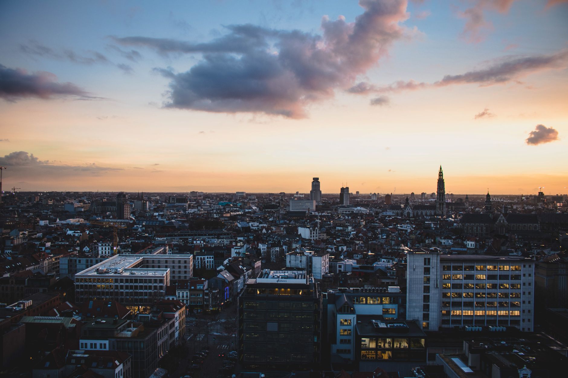 A stunning aerial view of Antwerp, Belgium, cityscape at dusk with vibrant sky colors.