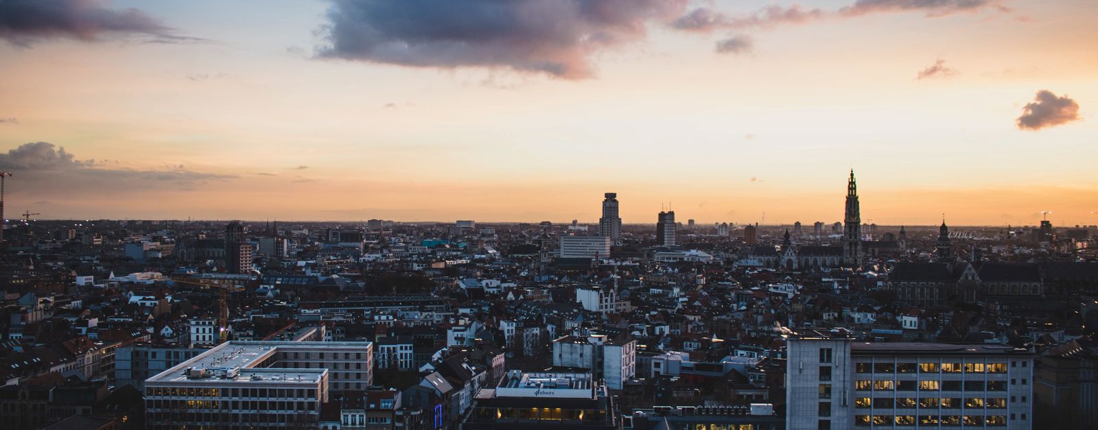 A stunning aerial view of Antwerp, Belgium, cityscape at dusk with vibrant sky colors.