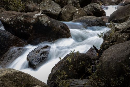 Free A tranquil waterfall cascading over rocks in a natural setting, showcasing serene beauty and wilderness. Stock Photo